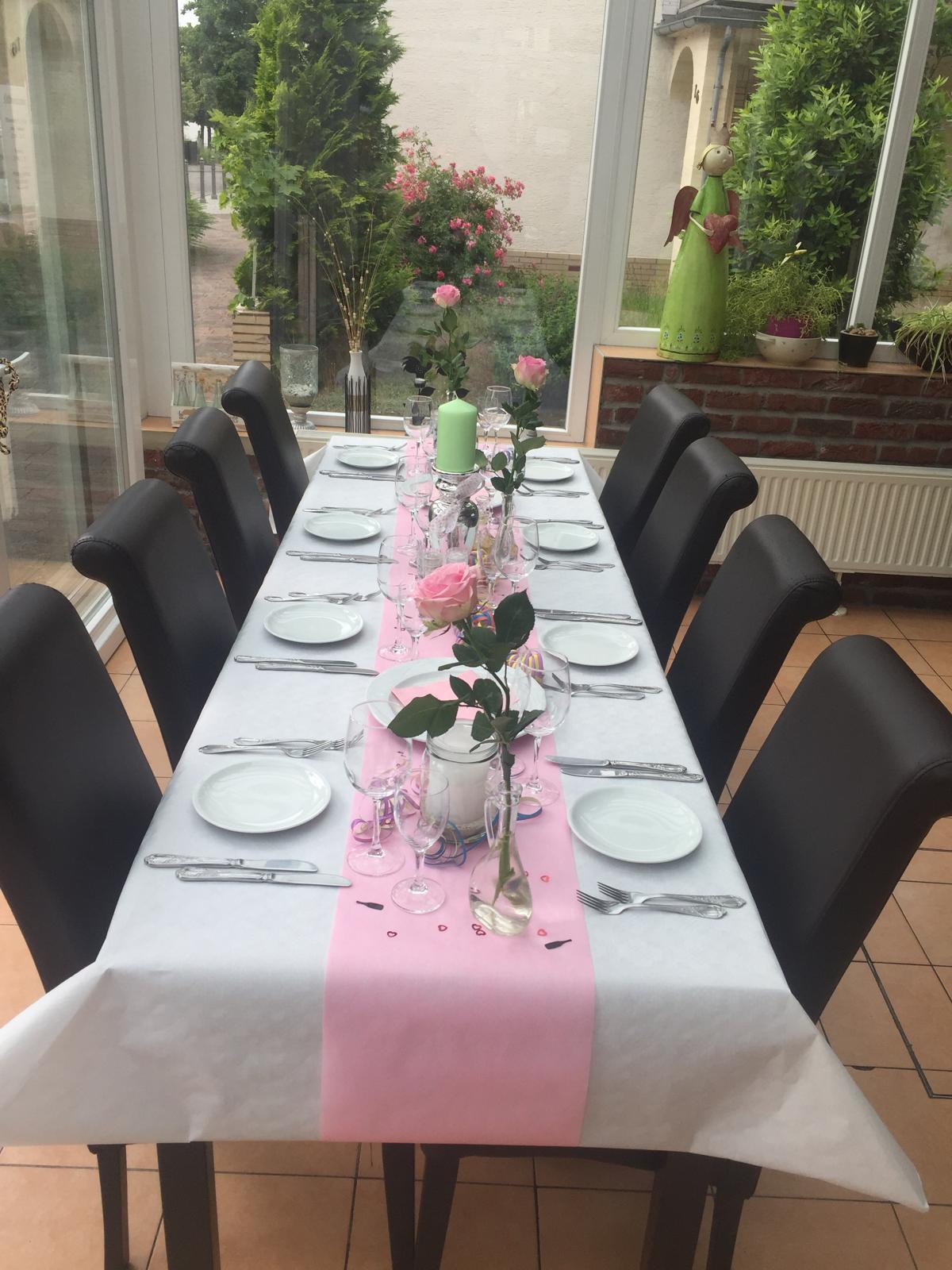 Lange Festtafel mit Rosen und Kerzen im Wintergarten
