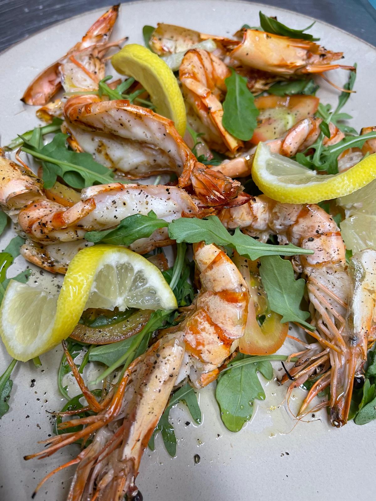 Gegrillte Scampi mit Zitronenscheiben und Rucola
