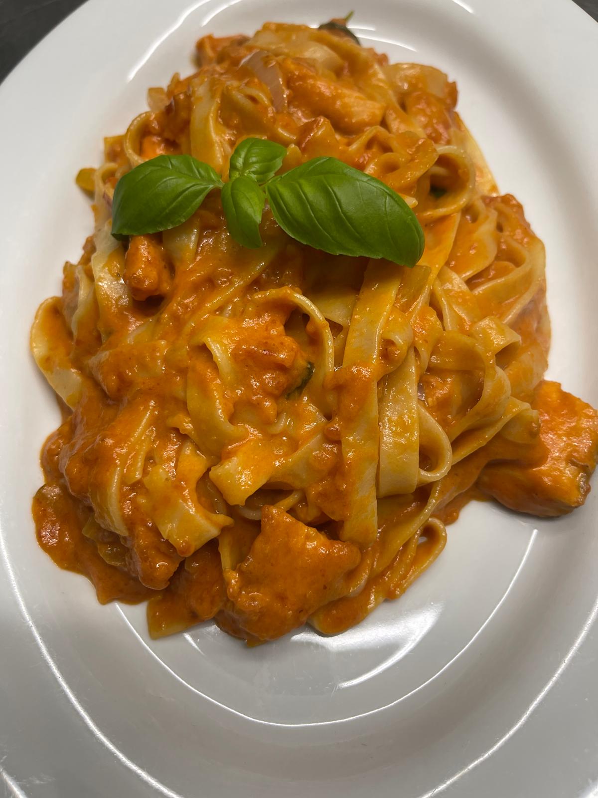 Tagliatelle mit zarten Filetstreifen in Tomaten-Sahnesauce