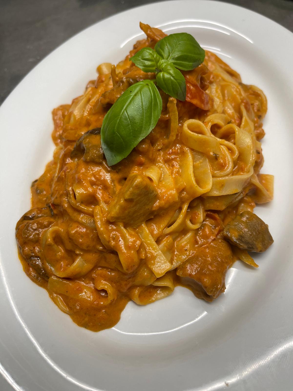 Tagliatelle mit Steinpilzen, frisch angerichtet mit Basilikum