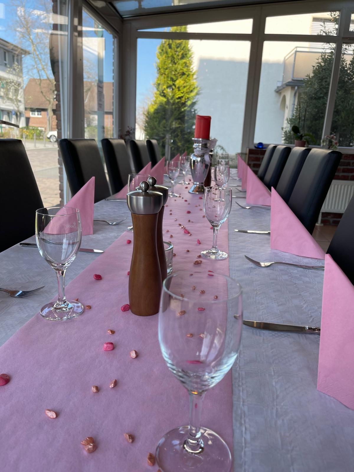 Tischdekoration mit Weingläsern und rosa Tischläufer